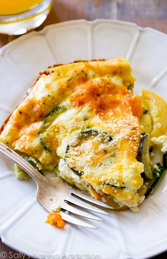 slice of crustless veggie quiche on a white plate with a fork